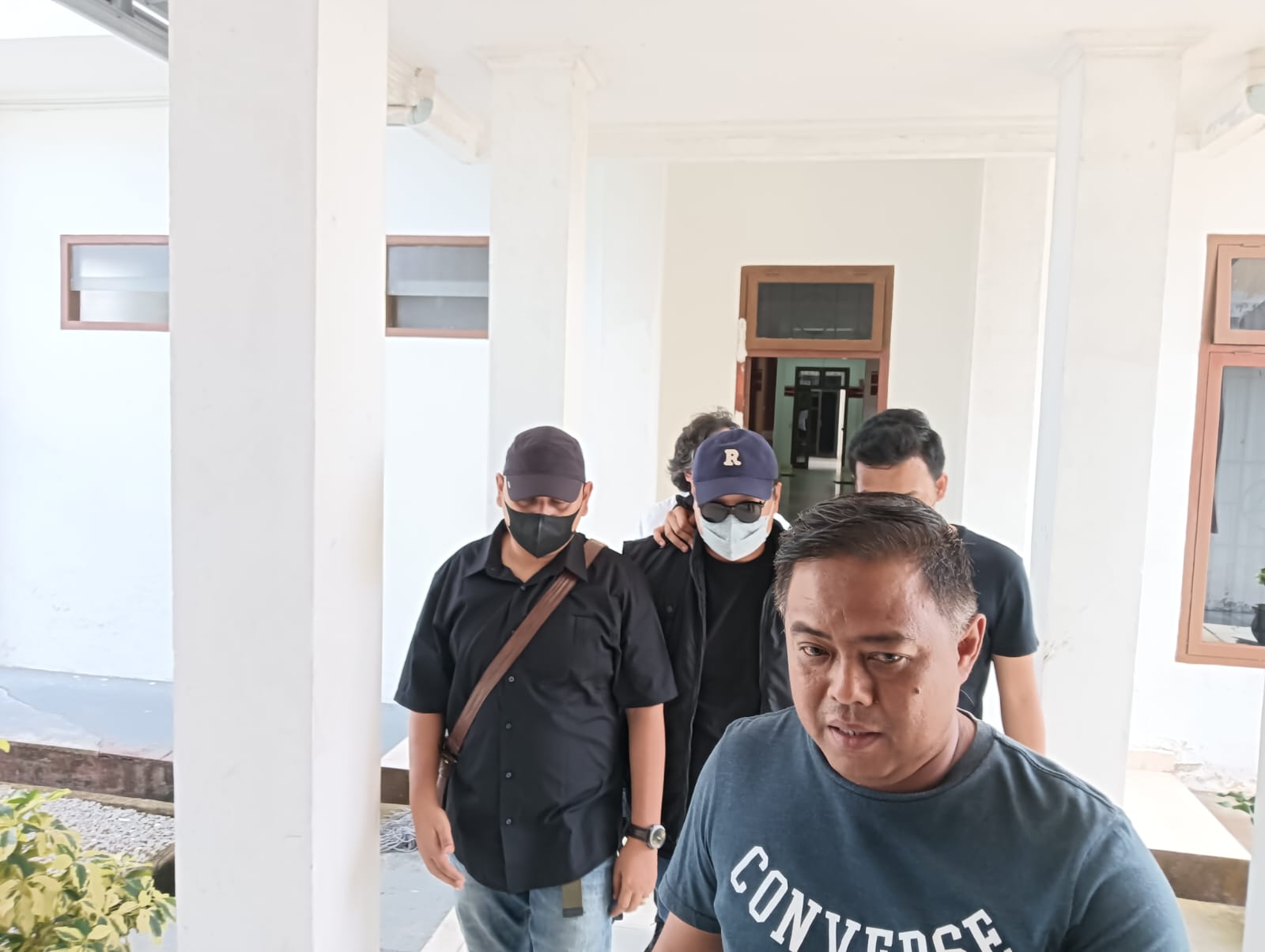 Caption: Frangky bos asal Pulau Belitung (topi biru/kacamata hitam) saat digiring penyidik ke gedung Pidsus Kejati Babel. (foto: dokbabelterkini.com)